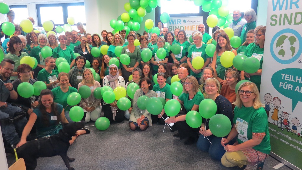  Viele Menschen in grünen T-Shirts und mit grünen Luftballons in der Hand.