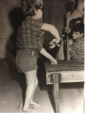 Schwarz,weiß: Das Kind steht und führt Übungen mit einem Stock in der Hand durch.