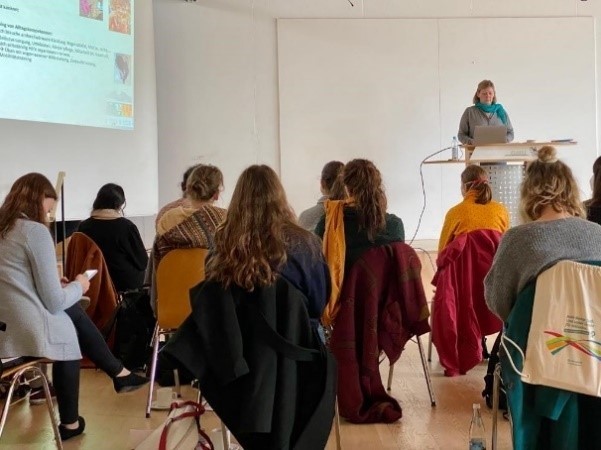 Mehrere Personen hören einem Vortrag zu