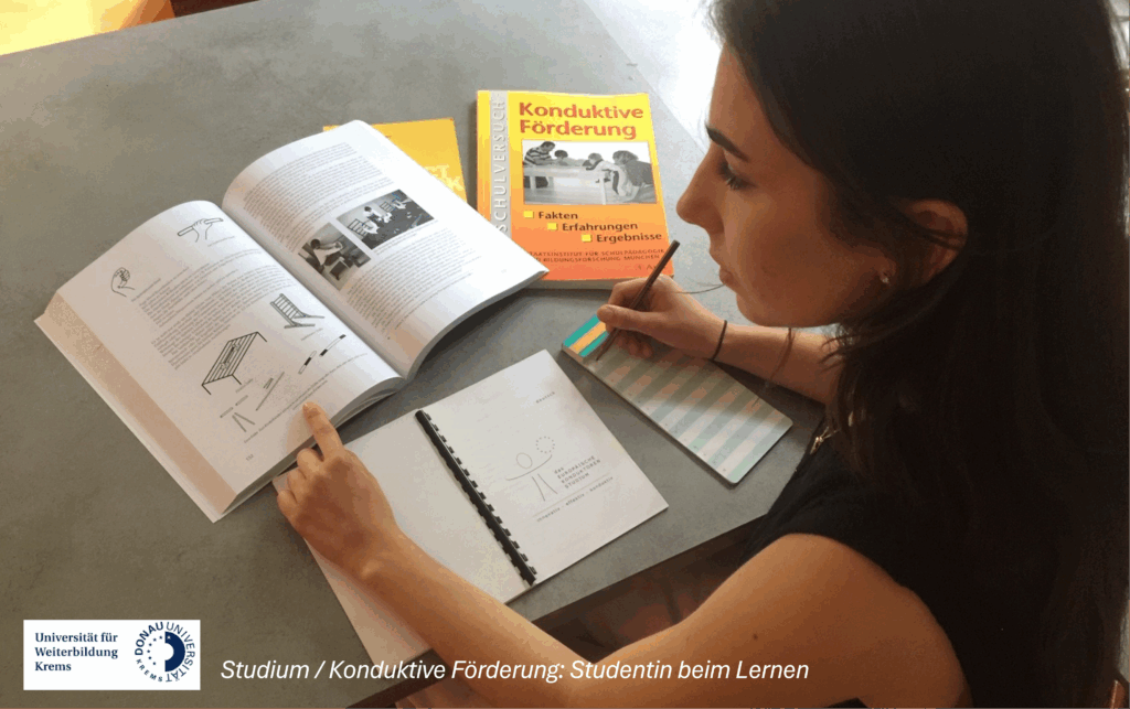 Studentin an Schreibtisch schaut in ein Buch